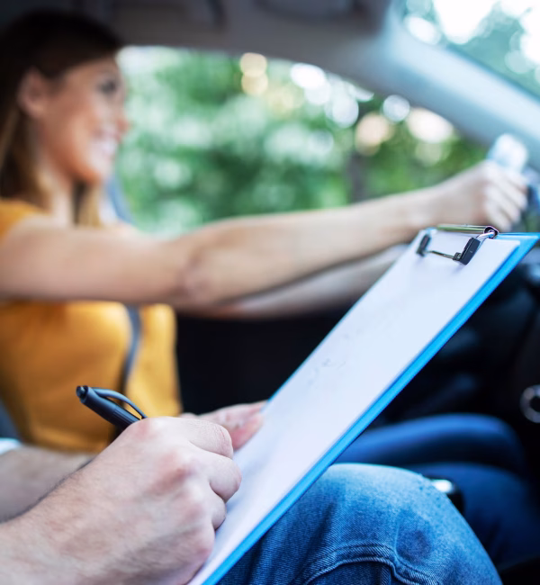 vista-ravvicinata-dell-istruttore-di-guida-tenendo-la-lista-di-controllo-mentre-in-background-studentessa-sterzo-e-guida-di-auto_342744-688 (1)